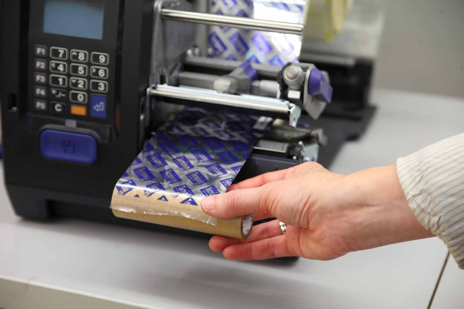 Pasar el rollo de ribbon bajo el cabezal de impresión